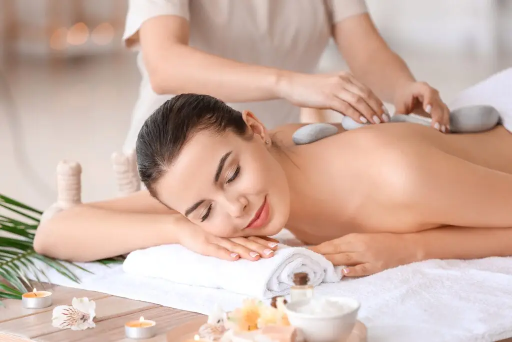 a young lady is getting swedish massage with hot stones